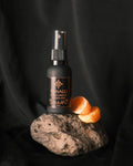 Tonalli Chilcuague Mandarin Honey oral spray on volcanic stone with fresh mandarin segments