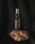 Tonalli Chilcuague Golden Root oral spray standing on volcanic stone against a black backdrop